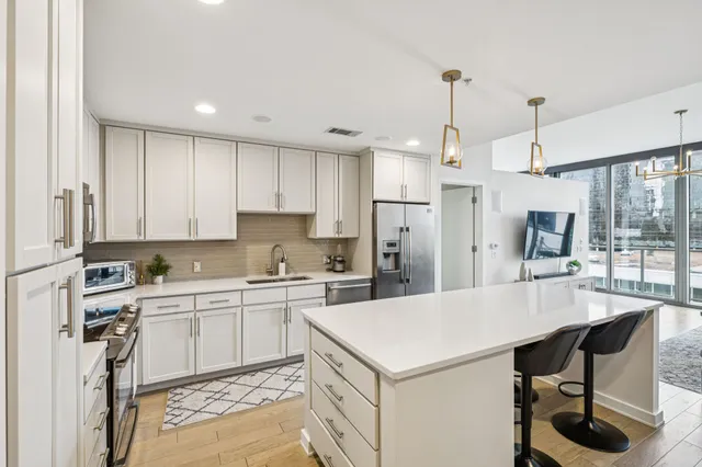 a kitchen with a sink a stove a refrigerator and cabinets