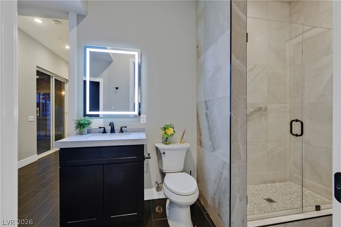6 Rue Du Ville Henderson, NV 89011 - Photo 52 of 99 This bathroom features a contemporary vanity, toilet, and a sleek, tiled shower with a glass enclosure.