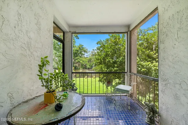 a porch with a table and a potted plant