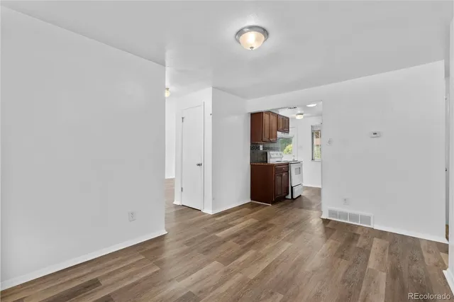 a view of a kitchen with wooden floor and a refrigerator