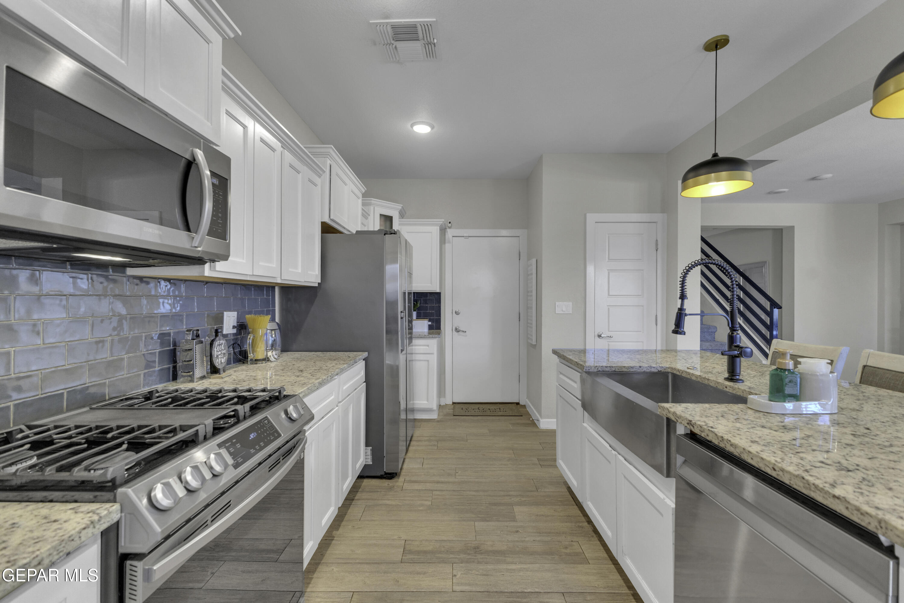 3529 Essence Street El Paso, TX 79938 - Photo 7 of 23 a kitchen with stainless steel appliances granite countertop a stove a sink and a refrigerator