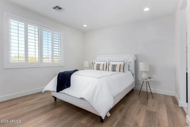 a bedroom with a bed and wooden floor