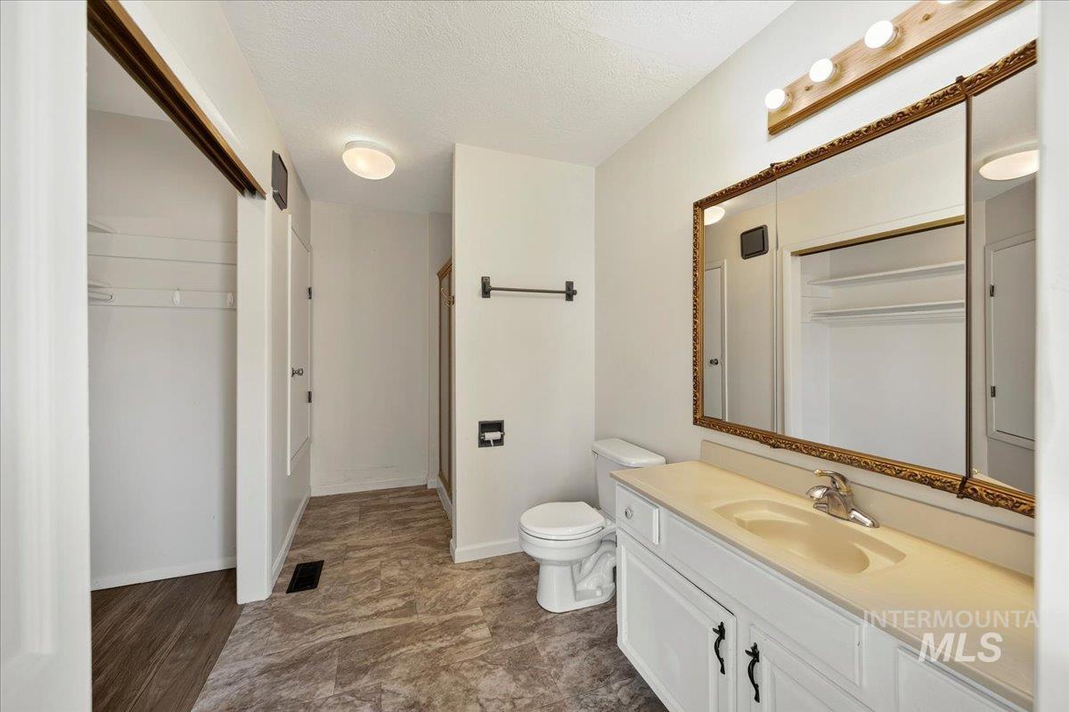 2160 South Five Mile Road Boise, ID 83709 - Photo 22 of 41 Vanity featuring a single-basin sink, light-toned countertop, and white cabinetry with black hardware