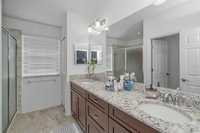 a bathroom with double vanity and a mirror