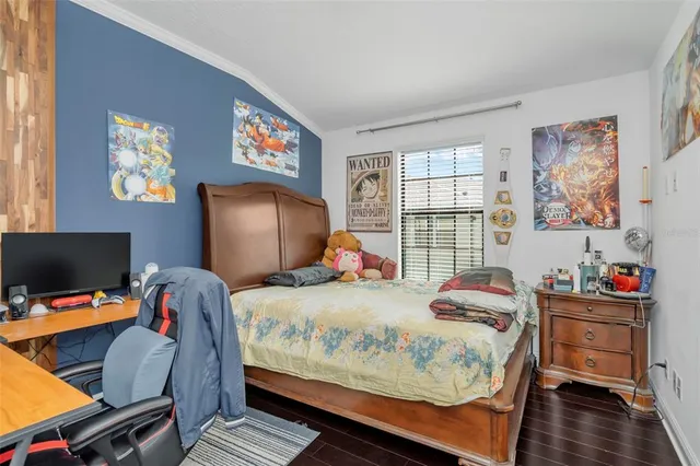 a bedroom with a bed and wooden floor