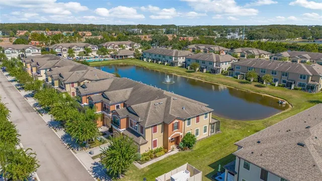 an aerial view of residential houses with outdoor space and lake view