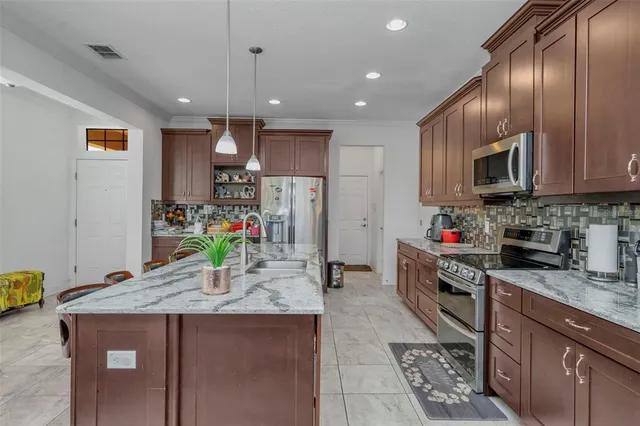 a kitchen with stainless steel appliances granite countertop a sink stove and refrigerator