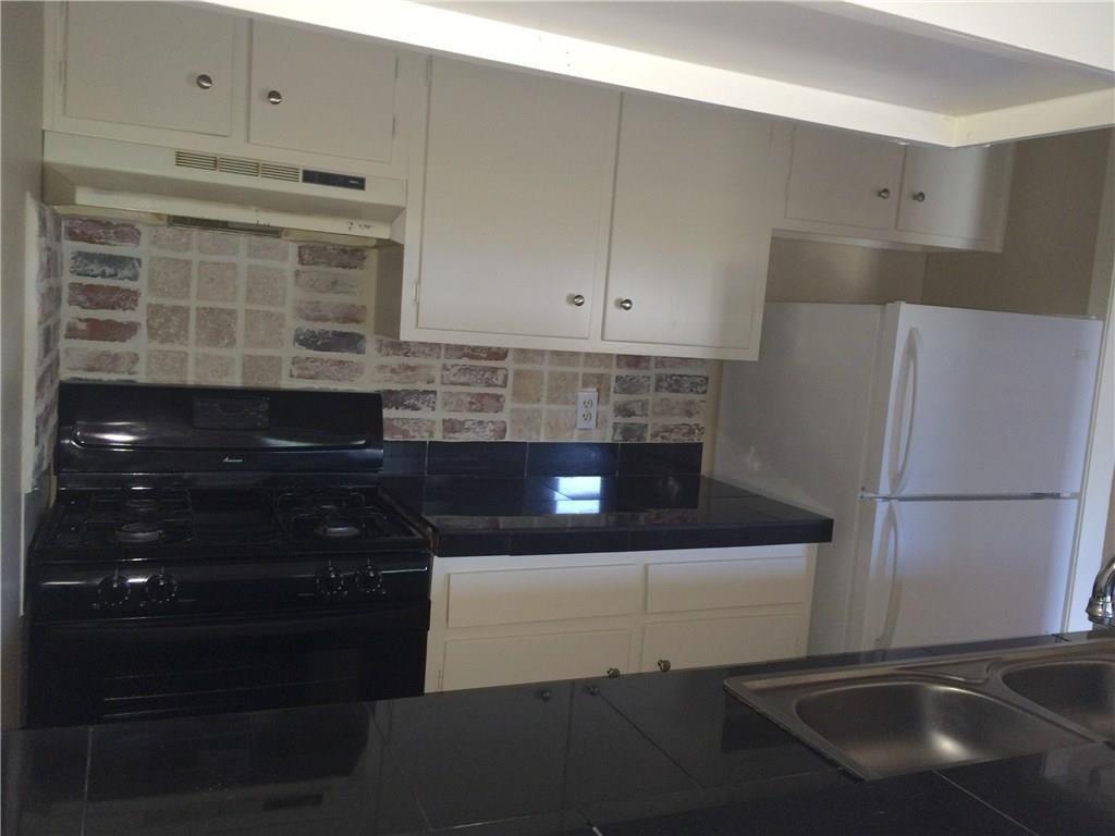 602 West 51st Street, Unit 101 Austin, TX 78751 - Photo 8 of 16 a kitchen with a sink and a refrigerator