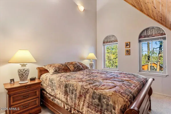 a bed sitting in a bedroom next to a window with large kitchen area