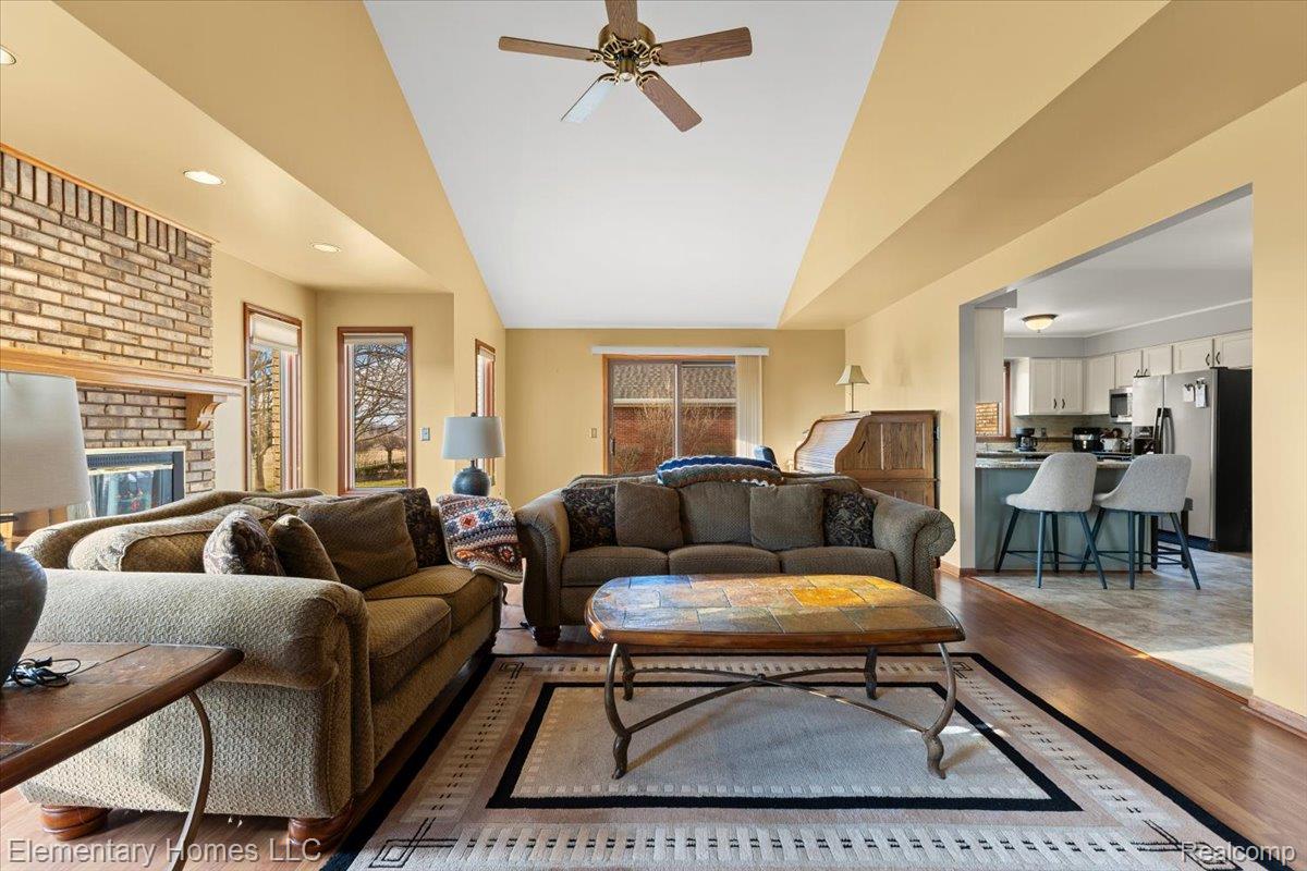 51637 Baker Road New Baltimore, MI 48047 - Photo 25 of 47 Living room featuring light wood-style floors, a ceiling fan, a fireplace, and recessed lighting