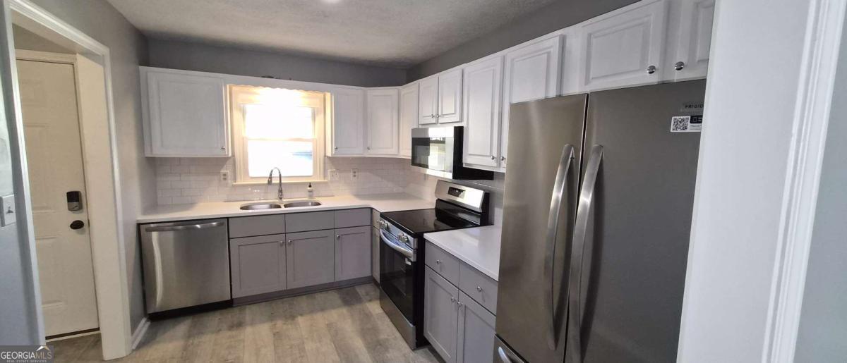 595 Macon Highway, Unit 5 Athens, GA 30606 - Photo 7 of 15 a kitchen with stainless steel appliances a refrigerator sink and cabinets