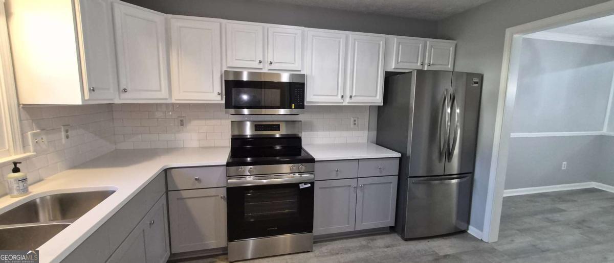 595 Macon Highway, Unit 5 Athens, GA 30606 - Photo 8 of 15 a kitchen with refrigerator a stove a sink and cabinets