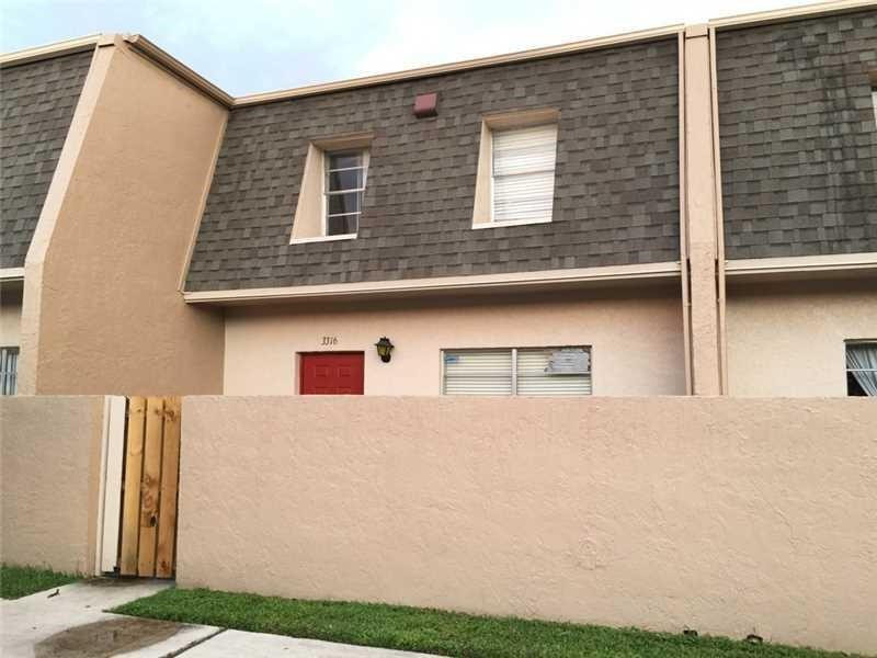 3316 Quail Close, Unit 21 Pompano Beach, FL 33064 - Photo 1 of 13 a front view of a house with garage