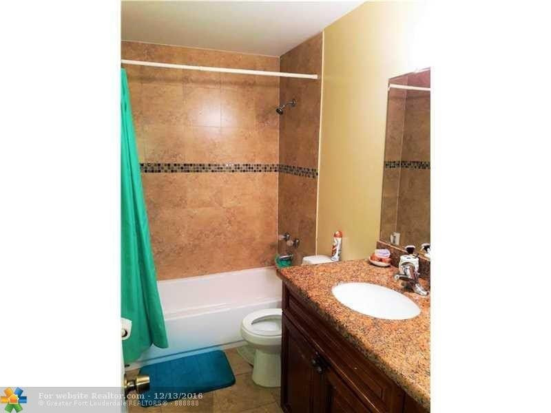 3316 Quail Close, Unit 21 Pompano Beach, FL 33064 - Photo 11 of 13 a bathroom with a granite countertop sink toilet and shower