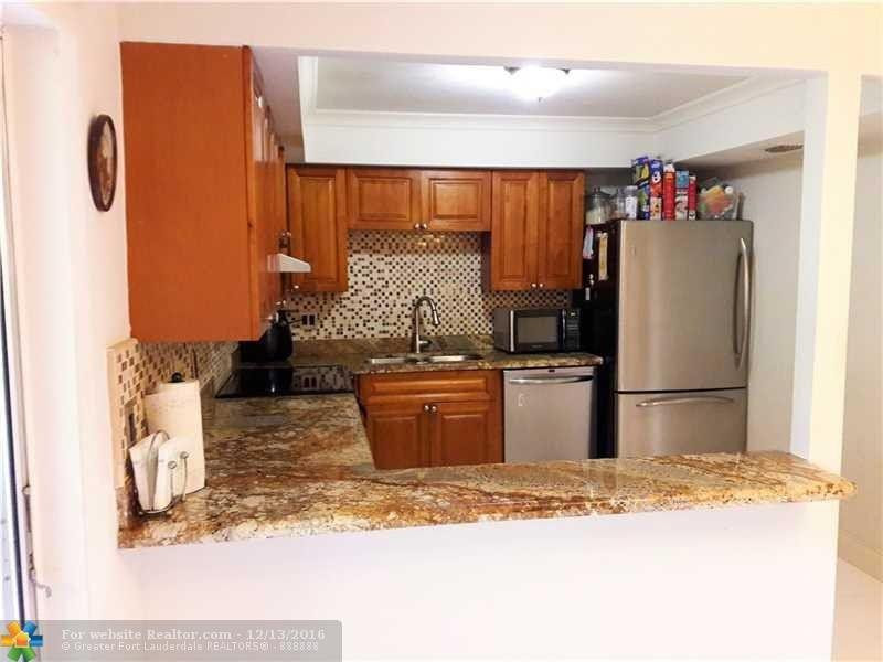 3316 Quail Close, Unit 21 Pompano Beach, FL 33064 - Photo 3 of 13 a kitchen with a refrigerator and a sink