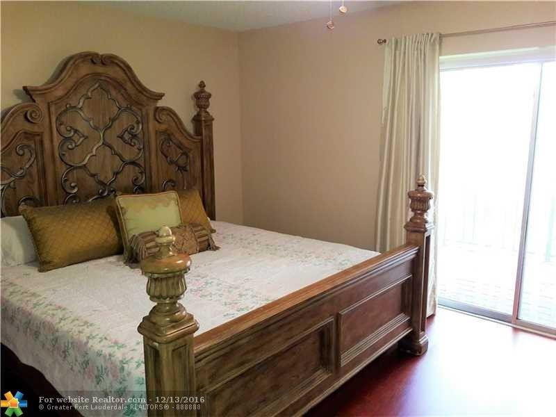 3316 Quail Close, Unit 21 Pompano Beach, FL 33064 - Photo 8 of 13 a bed sitting in a bedroom next to a window