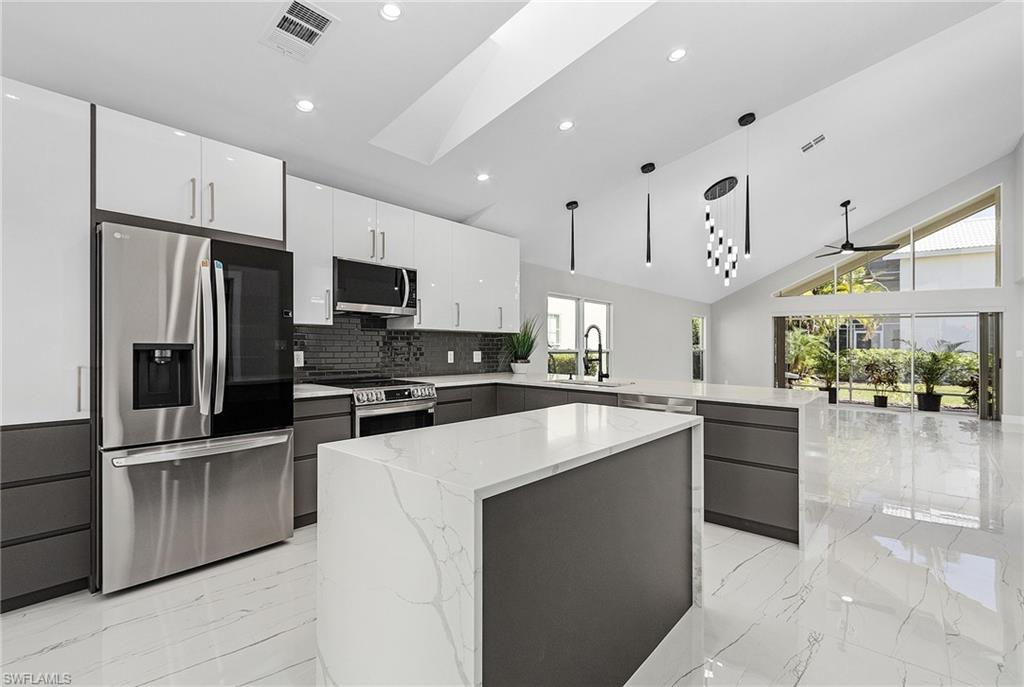 1601 Weybridge Circle, Unit 11 Naples, FL 34110 - Photo 1 of 34 a kitchen with cabinets and stainless steel appliances