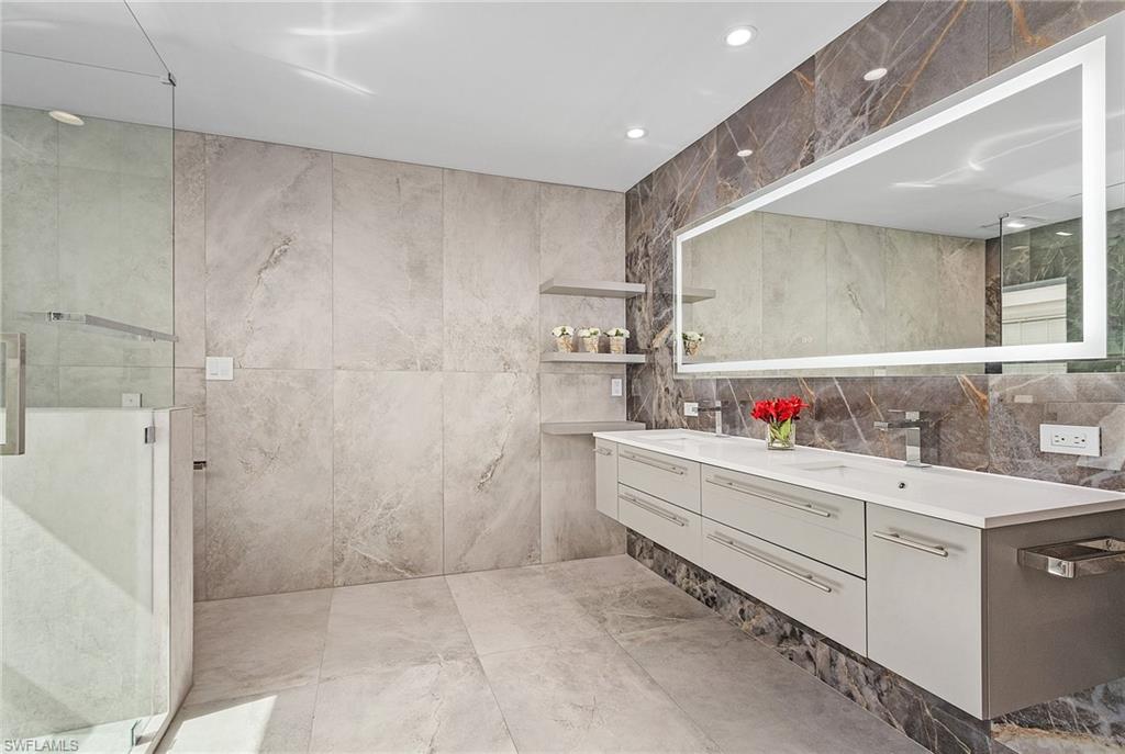 1601 Weybridge Circle, Unit 11 Naples, FL 34110 - Photo 12 of 34 a bathroom with a bathtub sink and mirror