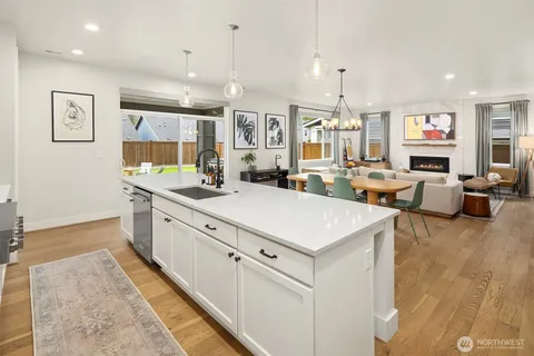 a kitchen that has a lot of cabinets a sink and a wooden floor