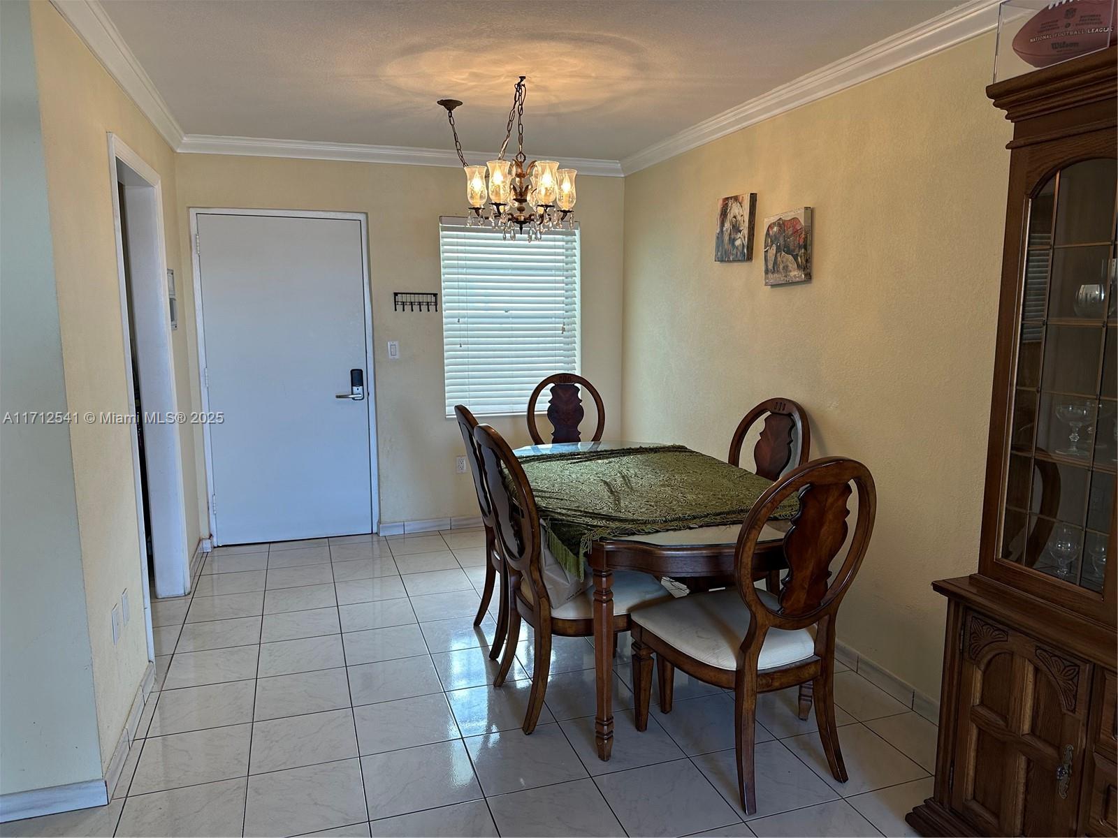720 Collins Avenue, Unit 404 Miami Beach, FL 33139 - Photo 4 of 19 a view of a dining room with furniture and chandelier