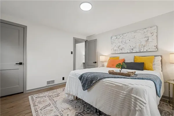 a bedroom with bed and wooden floor