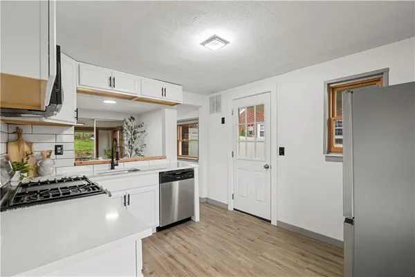 a large white kitchen with cabinets a sink and a stove