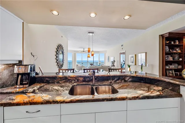 a kitchen with kitchen island granite countertop a sink a counter top space and cabinets