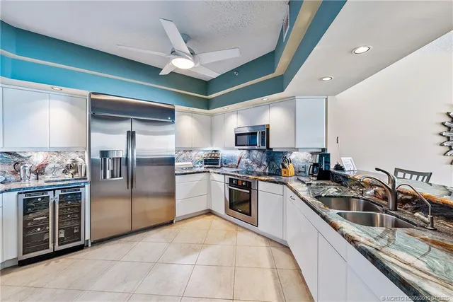 a kitchen with stainless steel appliances granite countertop a sink a stove and cabinets
