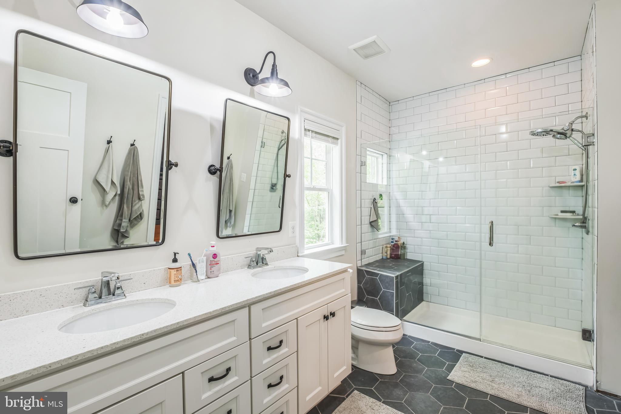 166 Nutwell Road Lothian, MD 20711 - Photo 19 of 29 a bathroom with a double vanity sink toilet mirror and shower