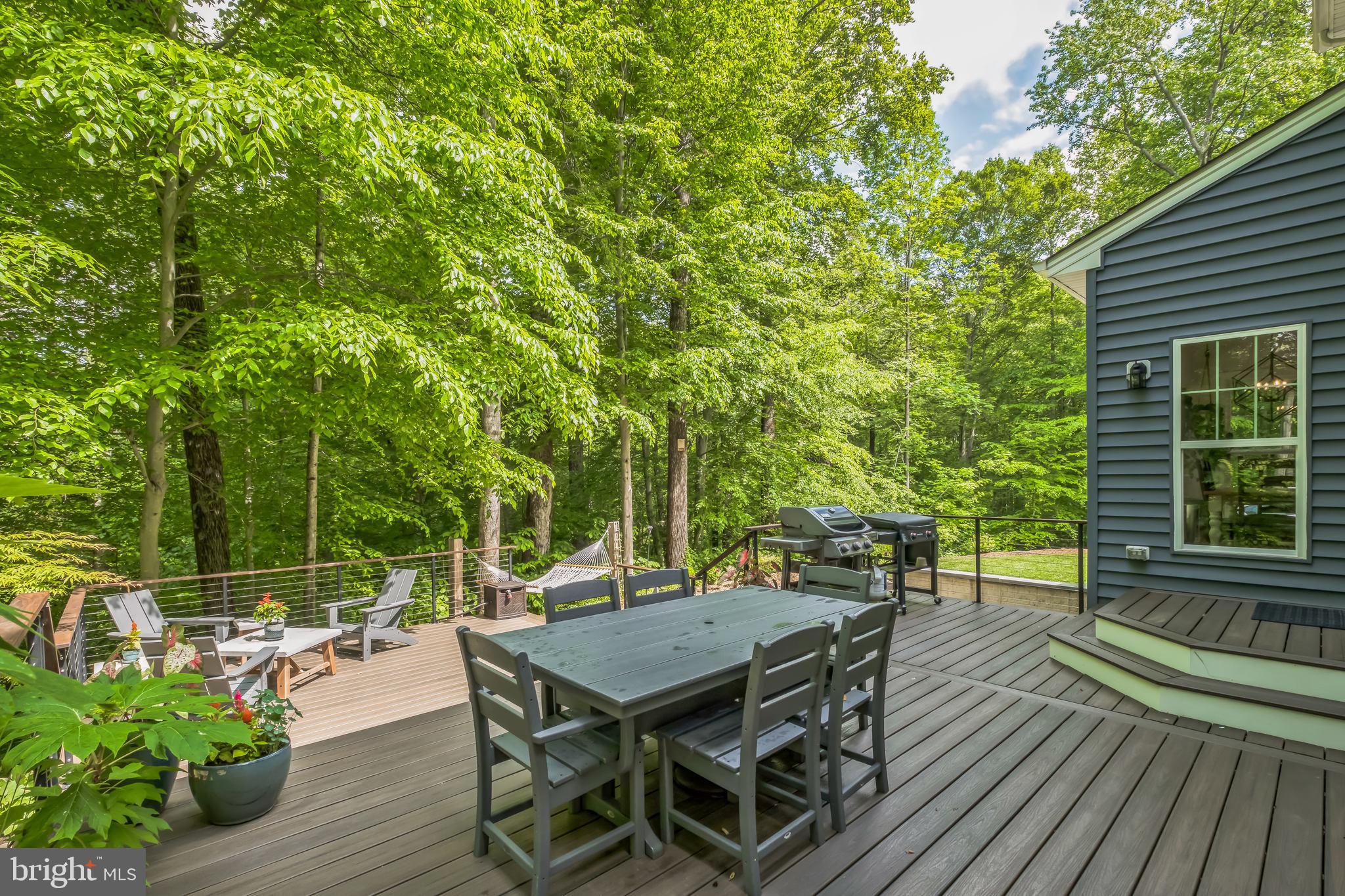 166 Nutwell Road Lothian, MD 20711 - Photo 26 of 29 a view of a patio with table and chairs and potted plants with wooden floor and fence