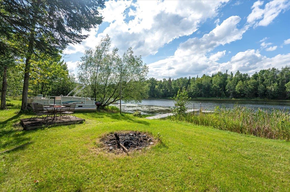 8977 Austin Road Alborn, MN 55702 - Photo 19 of 35 View of grassy yard featuring a water view and a fire pit