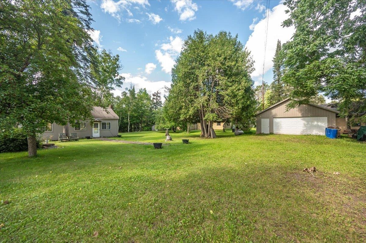 8977 Austin Road Alborn, MN 55702 - Photo 20 of 35 View of grassy yard with a detached garage and an outdoor structure