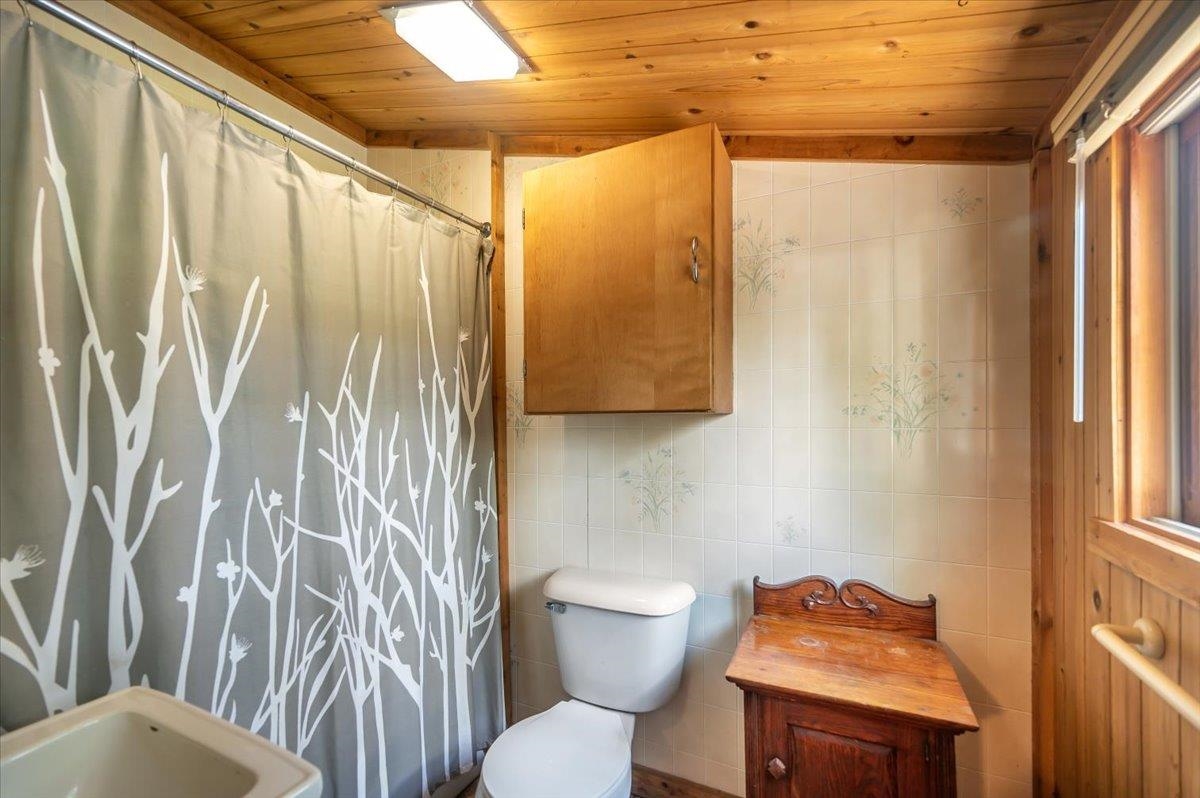 8977 Austin Road Alborn, MN 55702 - Photo 3 of 35 Full bathroom with tile walls, wood ceiling, and curtained shower