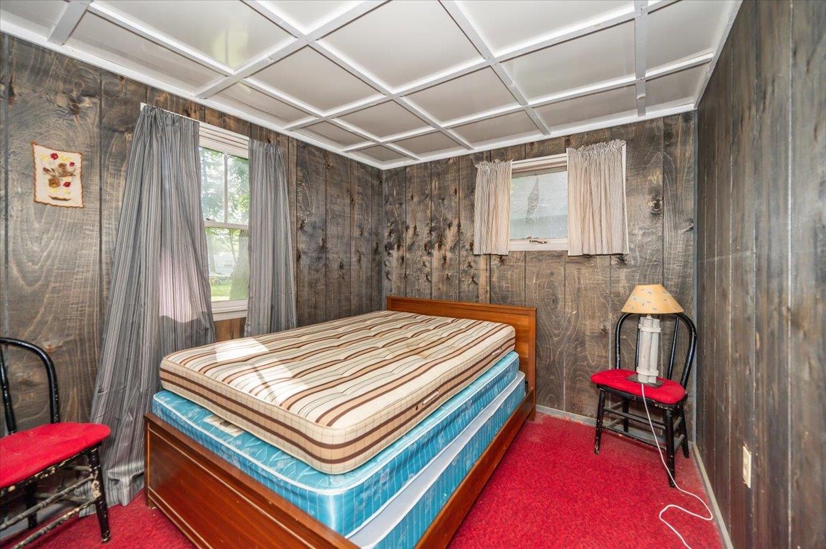8977 Austin Road Alborn, MN 55702 - Photo 33 of 35 Carpeted bedroom featuring wooden walls and baseboards