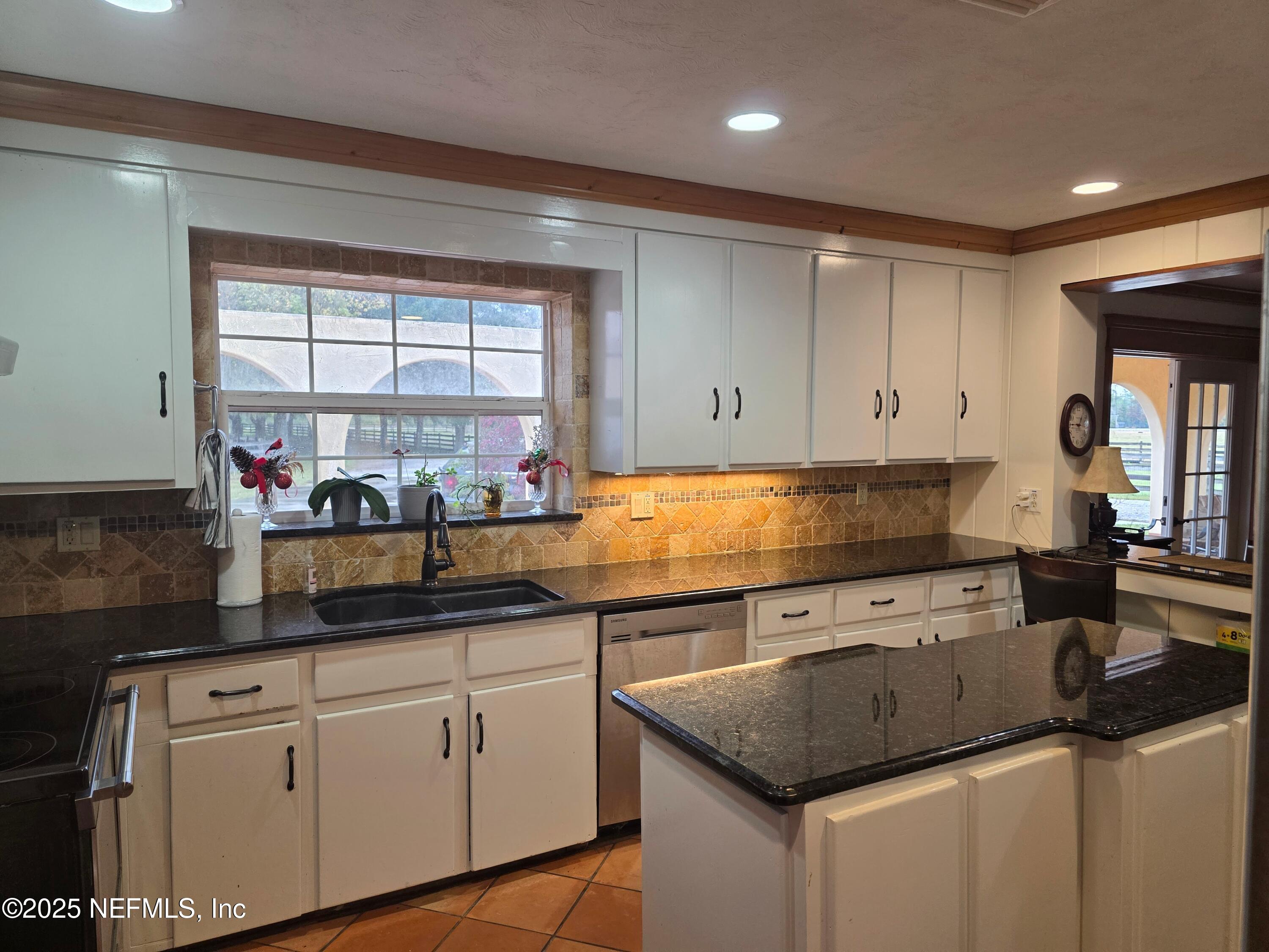 721 Bunnell Road Pierson, FL 32180 - Photo 18 of 59 a kitchen with stainless steel appliances granite countertop a sink window and cabinets