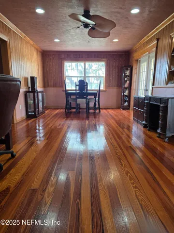a view of an empty room with wooden floor and closet