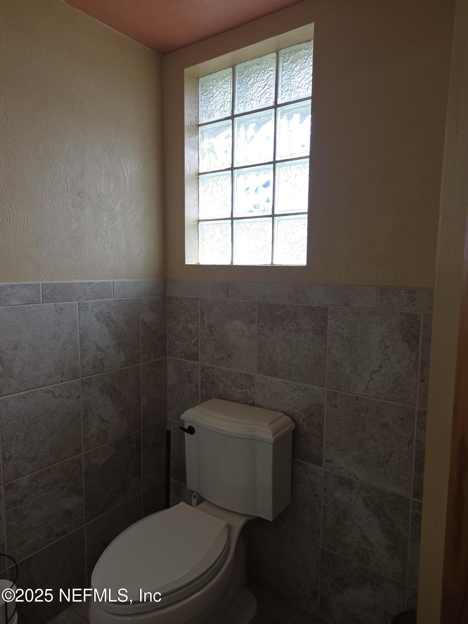 721 Bunnell Road Pierson, FL 32180 - Photo 42 of 59 a white toilet sitting in a bathroom next to a window