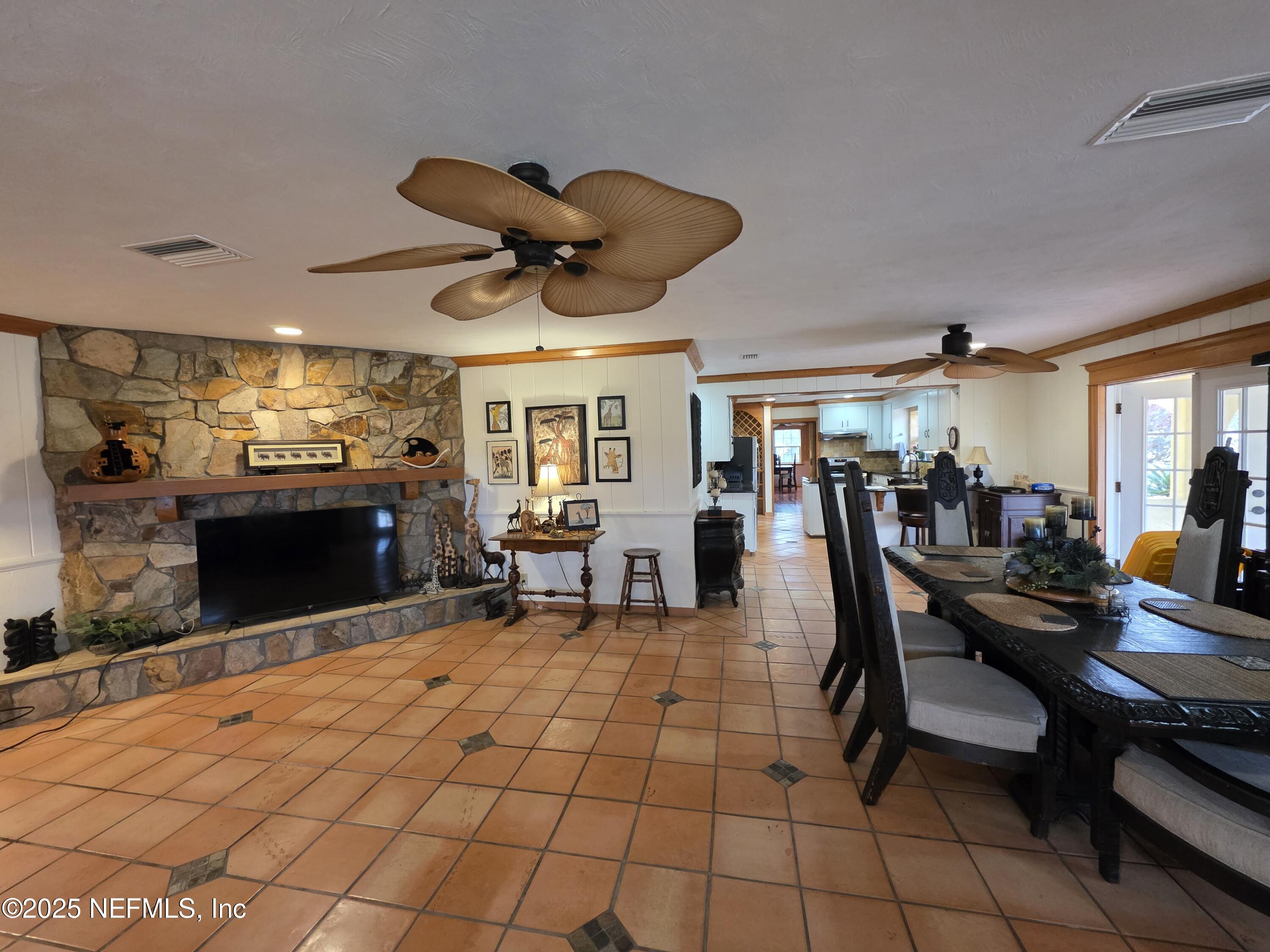 721 Bunnell Road Pierson, FL 32180 - Photo 9 of 59 a living room with furniture a dining table and a fireplace