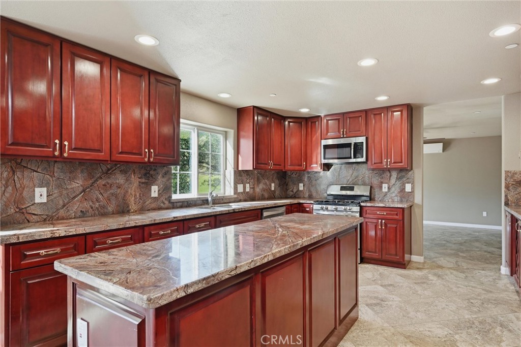 26200 Morgan Valley Road Lower Lake, CA 95457 - Photo 6 of 69 a kitchen with stainless steel appliances granite countertop wooden cabinets a sink and dishwasher a stove top oven with wooden floor