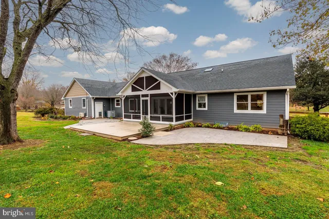 a front view of a house with swimming pool table and chairs