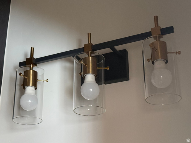 774 West 480 South American Fork, UT 84003 - Photo 29 of 76 Three-light vanity fixture featuring clear glass shades and brass-finish hardware mounted on a matte black bar
