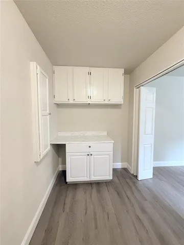 a kitchen with white cabinets and sink