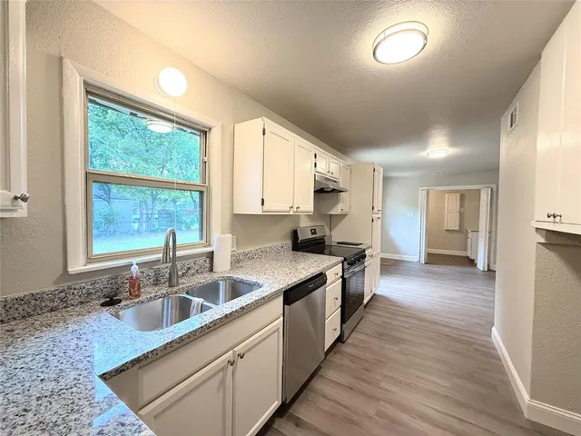 a kitchen with stainless steel appliances granite countertop a sink stove and cabinets