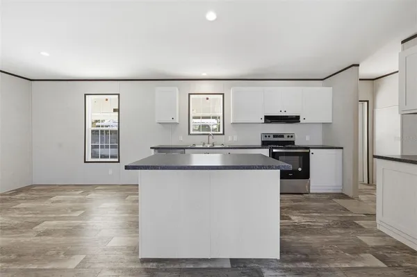 a kitchen with stainless steel appliances granite countertop a refrigerator a stove and a sink
