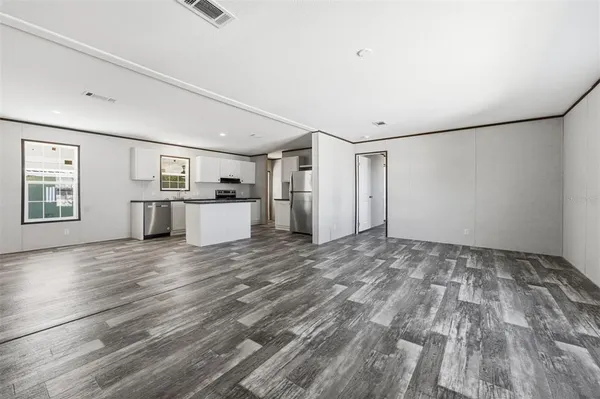 a view of empty room with wooden floor and window
