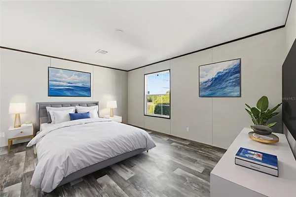a bedroom with a bed and a painting on the wall