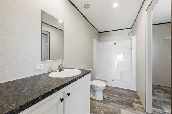 a bathroom with a granite countertop sink toilet and shower