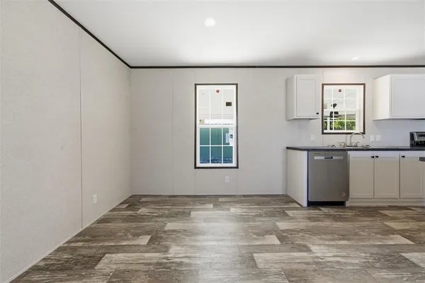 a view of a kitchen with wooden floor and window