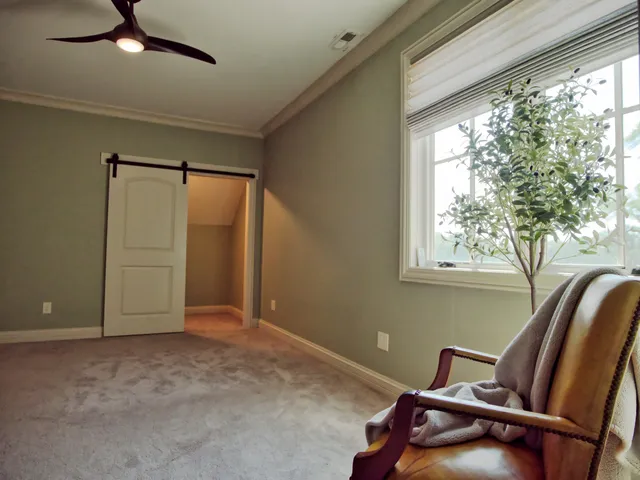 a view of staircase with lots of frames on wall and a window