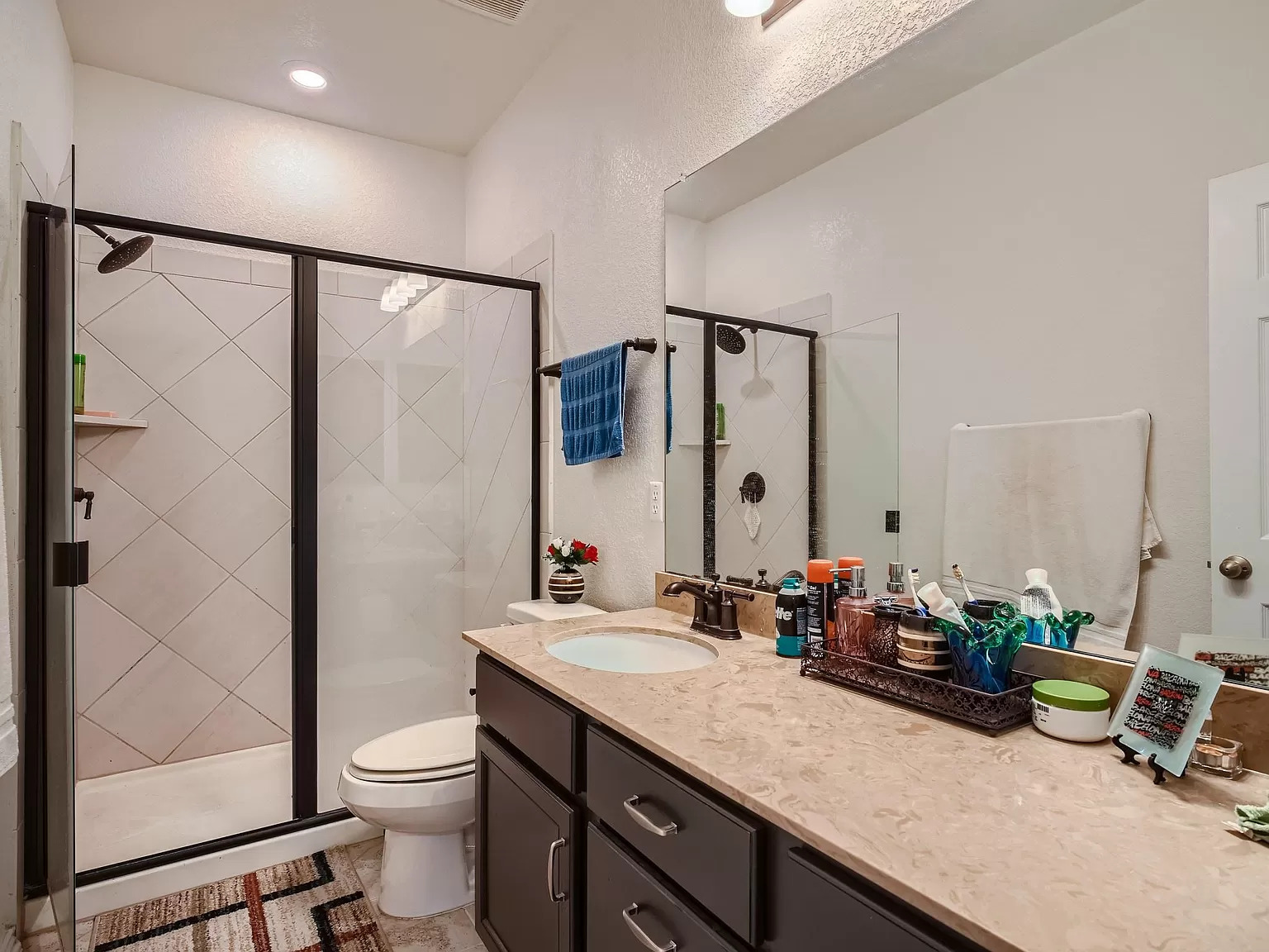 2471 Sunrise Road, Unit 64 Round Rock, TX 78664 - Photo 18 of 30 a bathroom with a granite countertop sink a toilet a mirror and shower
